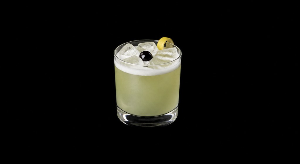 Absinthe Sour cocktail on a dark studio background