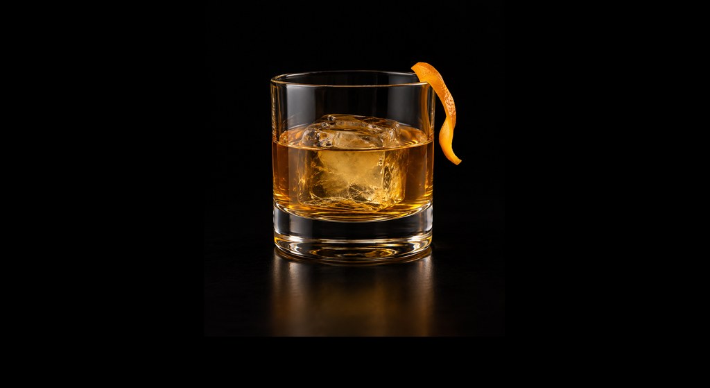 Añejo Old Fashioned cocktail on a dark studio background