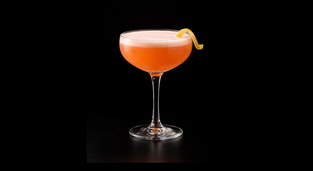 Aperol Sour cocktail on a dark studio background