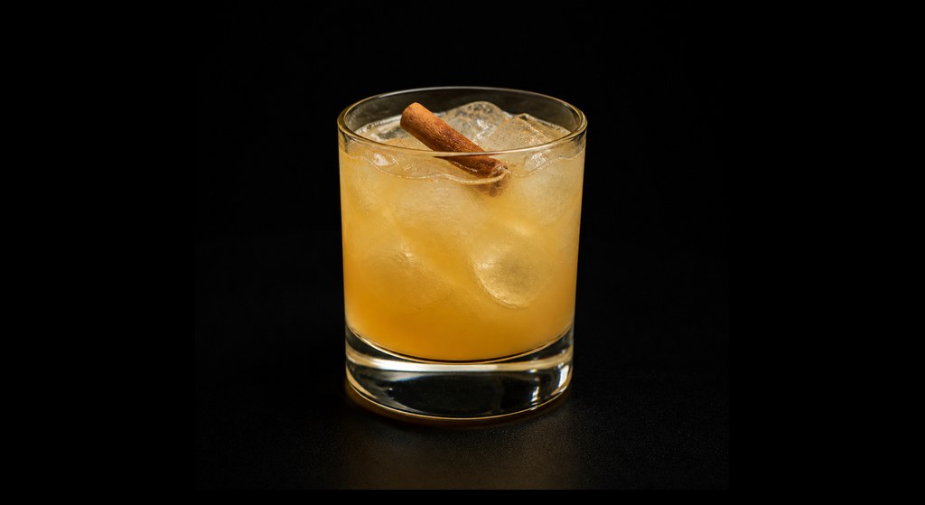 Applejack Rabbit (served long) cocktail on a dark studio background