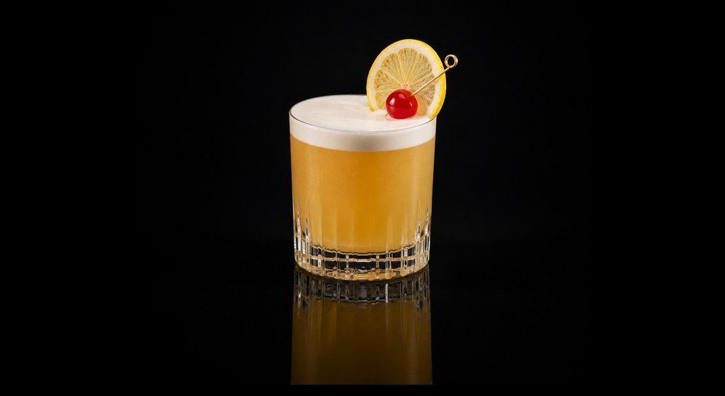 Apricot Lady Sour cocktail on a dark studio background