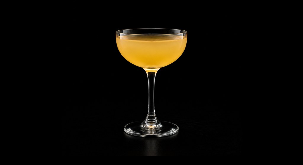 Banana Between the Sheets cocktail on a dark studio background
