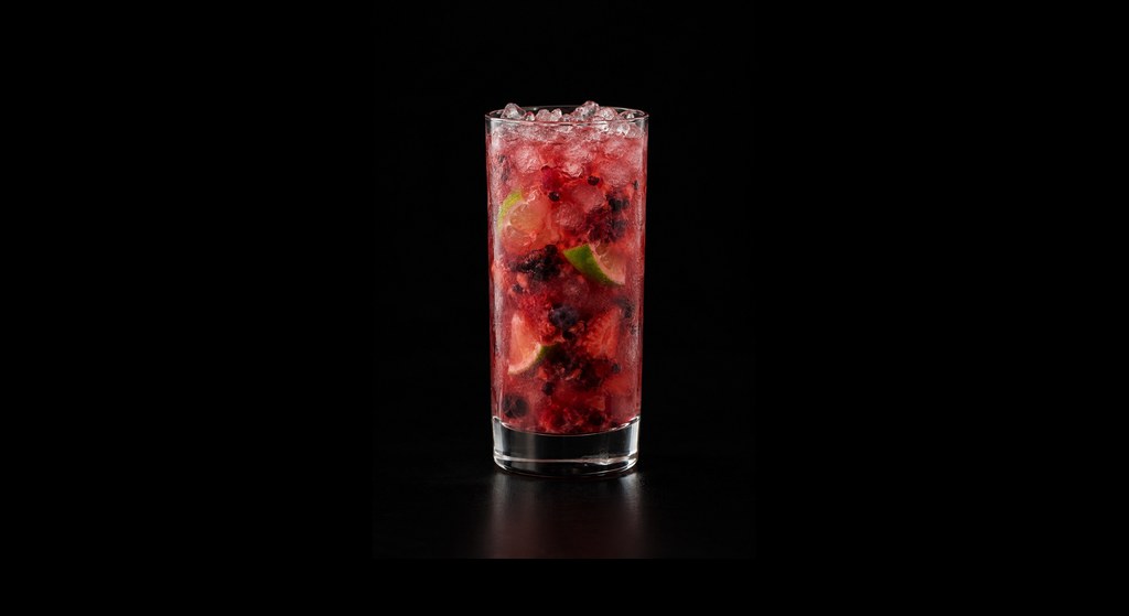 Berry Caipirinha cocktail on a dark studio background