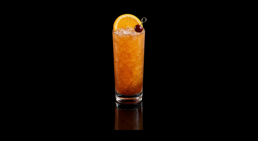 Black Rum Swizzle cocktail on a dark studio background
