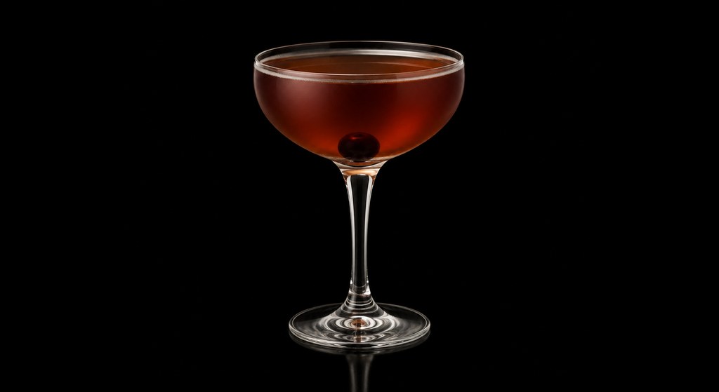 Black Rumhattan cocktail on a dark studio background