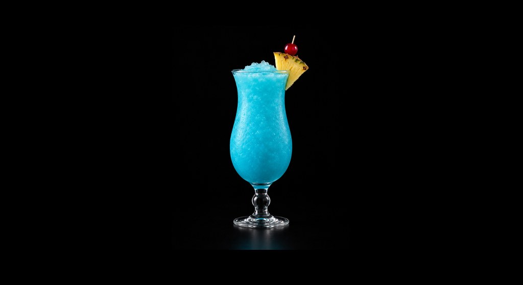 Blue Hawaiian cocktail on a dark studio background