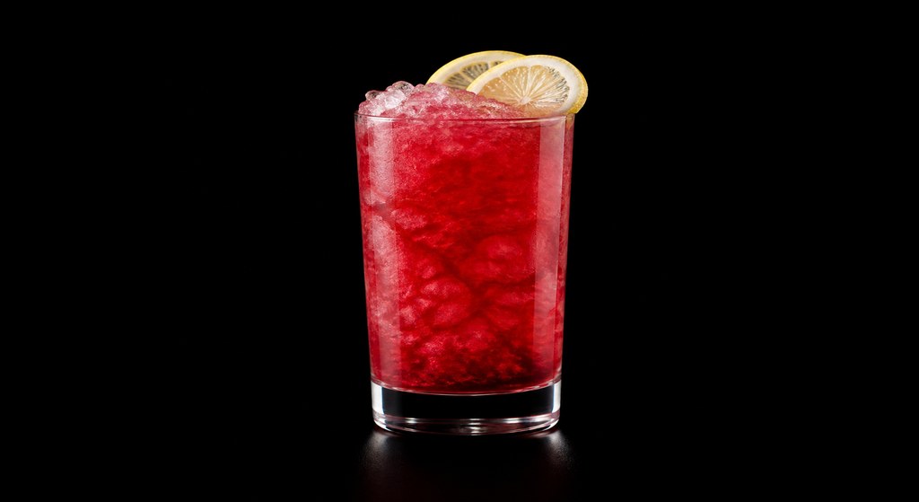Boozy Arnold Palmer cocktail on a dark studio background