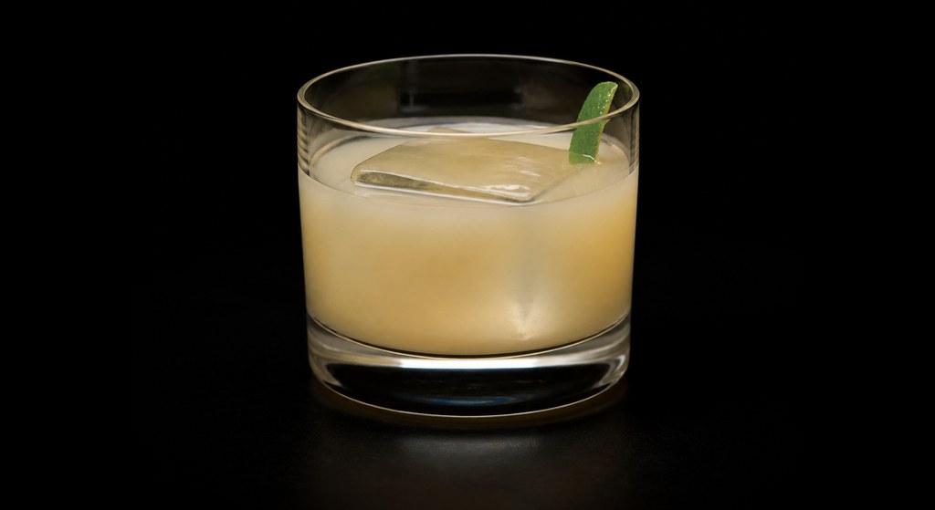 Chamomile Bourbon Milk Punch cocktail on a dark studio background