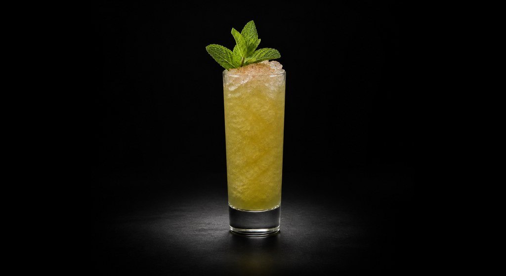 Chartreuse Swizzle cocktail on a dark studio background