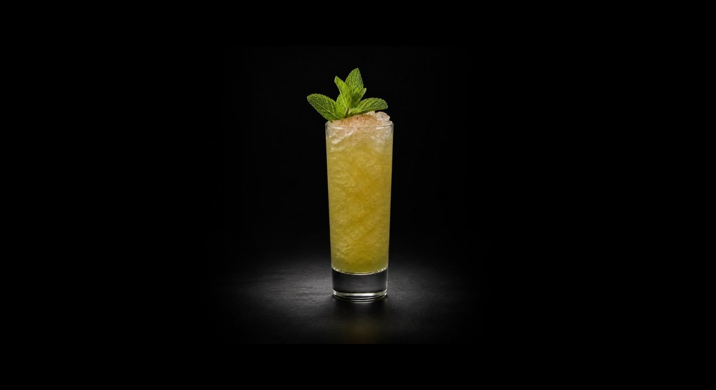 Chartreuse Swizzle cocktail on a dark studio background