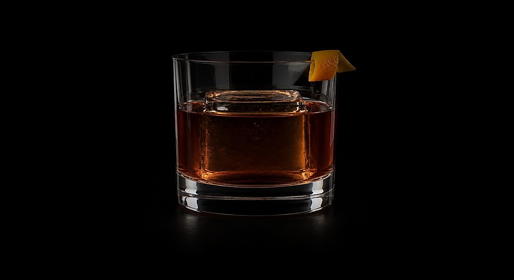 Coffee Old-Fashioned cocktail on a dark studio background