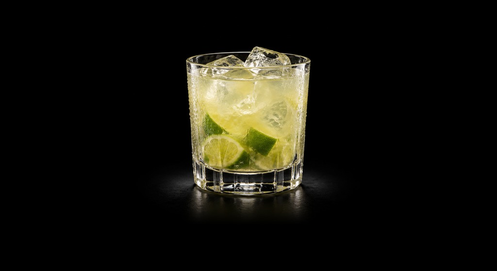 Dark Caipirinha cocktail on a dark studio background