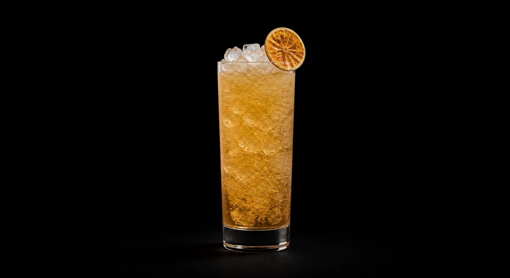 Fever! Til You Swizzle cocktail on a dark studio background