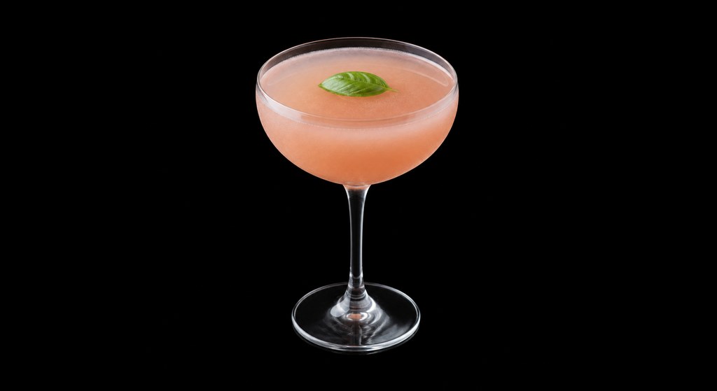 Grapefruit Basil Martini cocktail on a dark studio background
