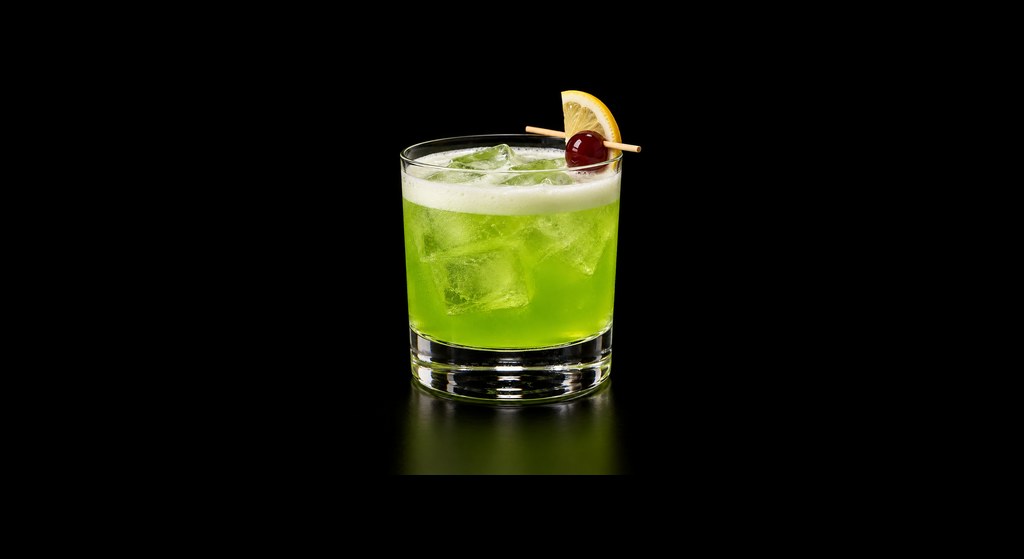 Green Melon Sour cocktail on a dark studio background