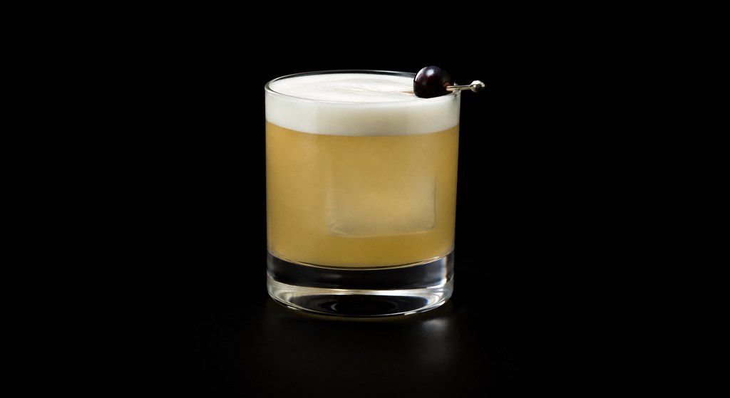 Irish Whiskey Sour cocktail on a dark studio background