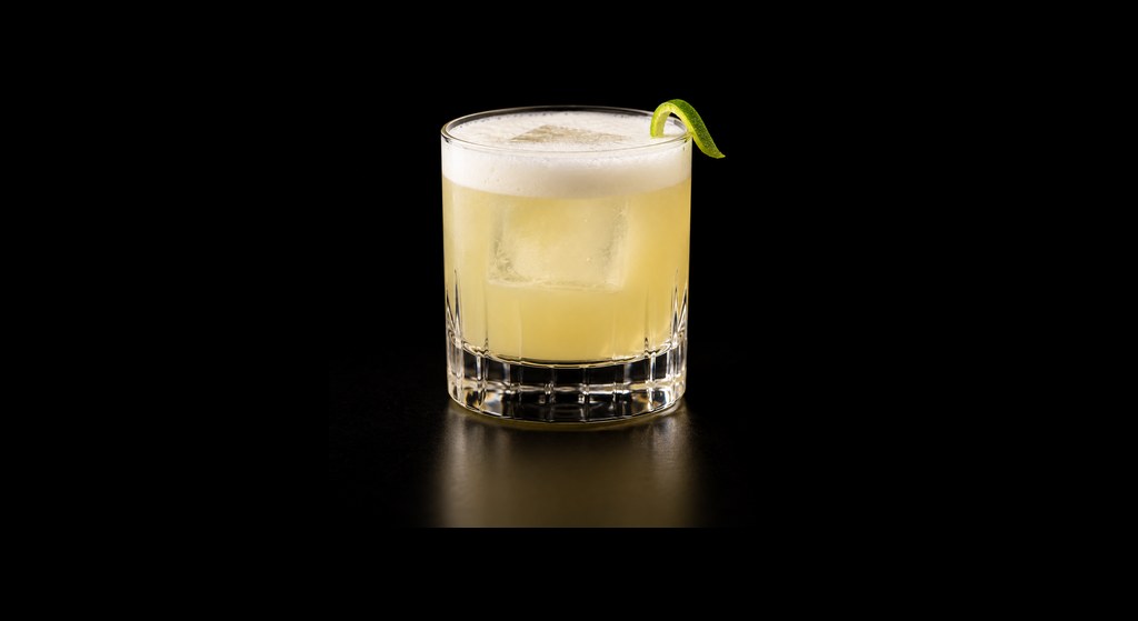 Limoncello Sour cocktail on a dark studio background