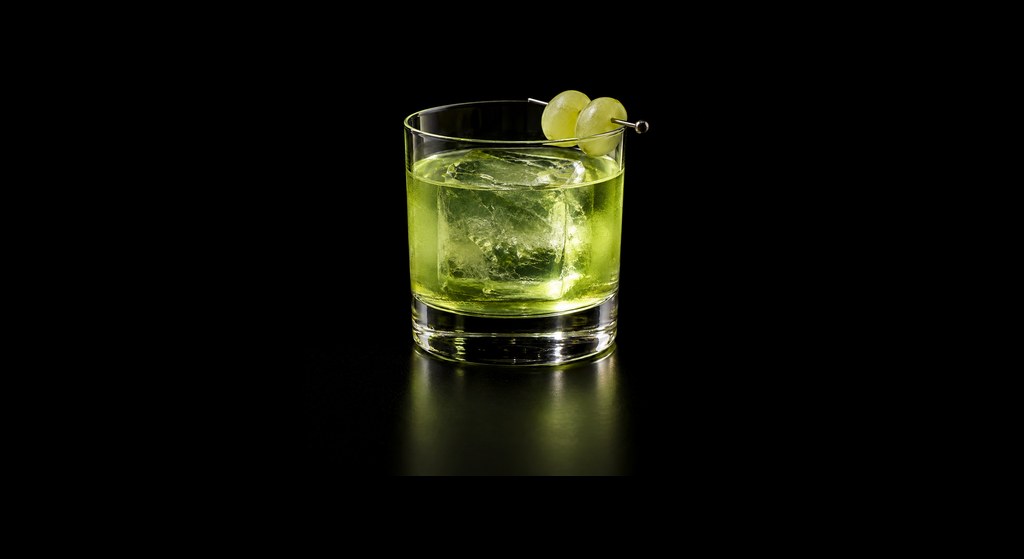 Midori Negroni cocktail on a dark studio background