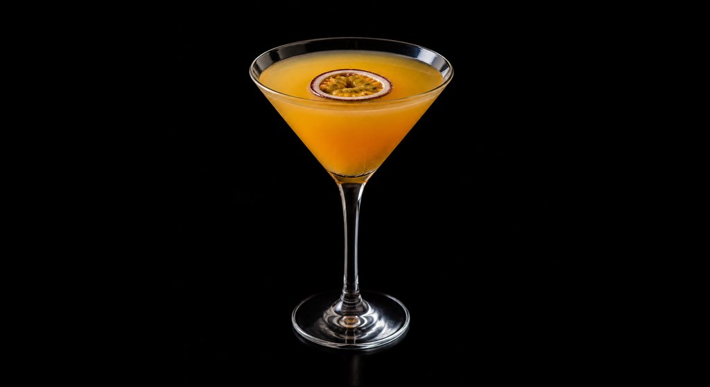 Passion Fruit Martini cocktail on a dark studio background