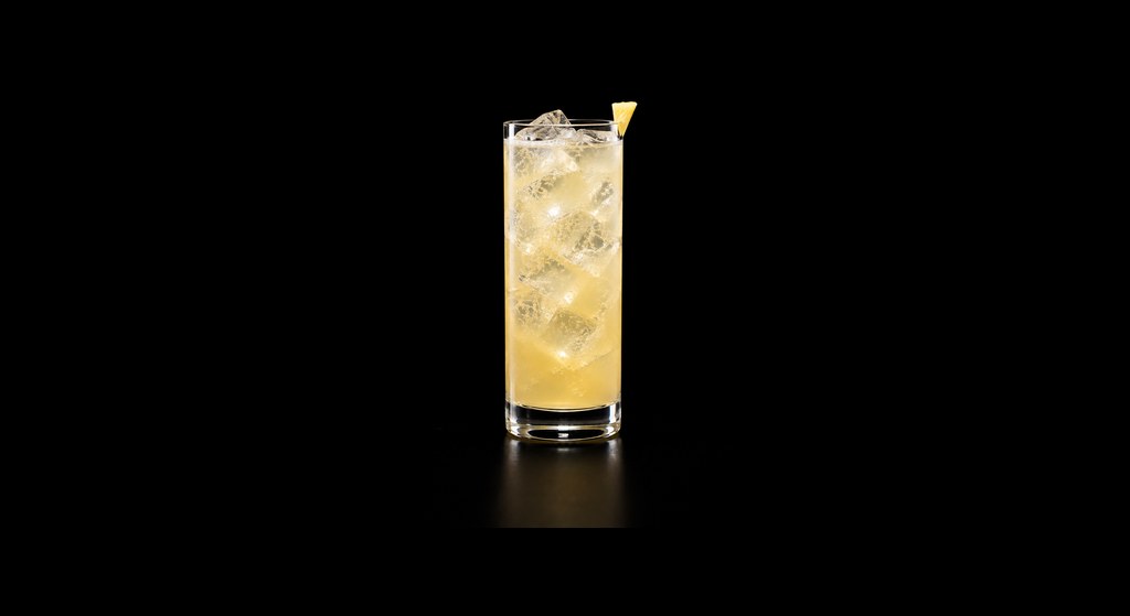 Pear & Pineapple Highball cocktail on a dark studio background