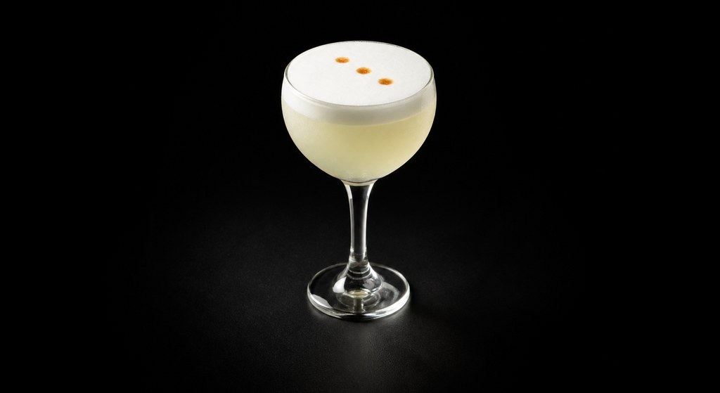 Pisco Sour cocktail on a dark studio background